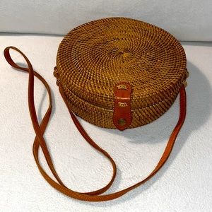 Round woven basket bag with leather accents